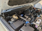 EXART Toyota Land Cruiser 250 air-cleaner-side Air Intake Stabilizer, alternate engine-bay angle. Sound Generator version shown; throttle-side product sold separately.